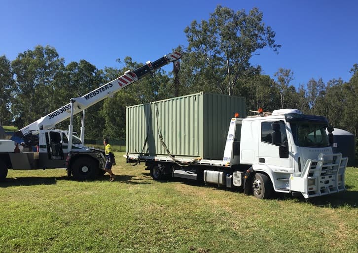 20ft used cargo worthy shipping container unload from crane with flatbed truck delivery from Container Traders