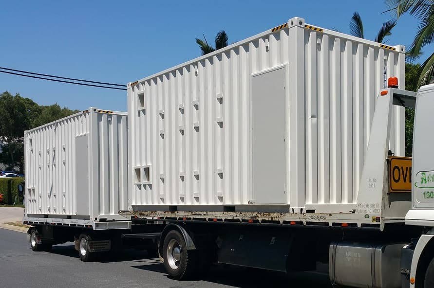 20ft shipping container switch room modifications with personnel access doors on delivery truck from Container Traders